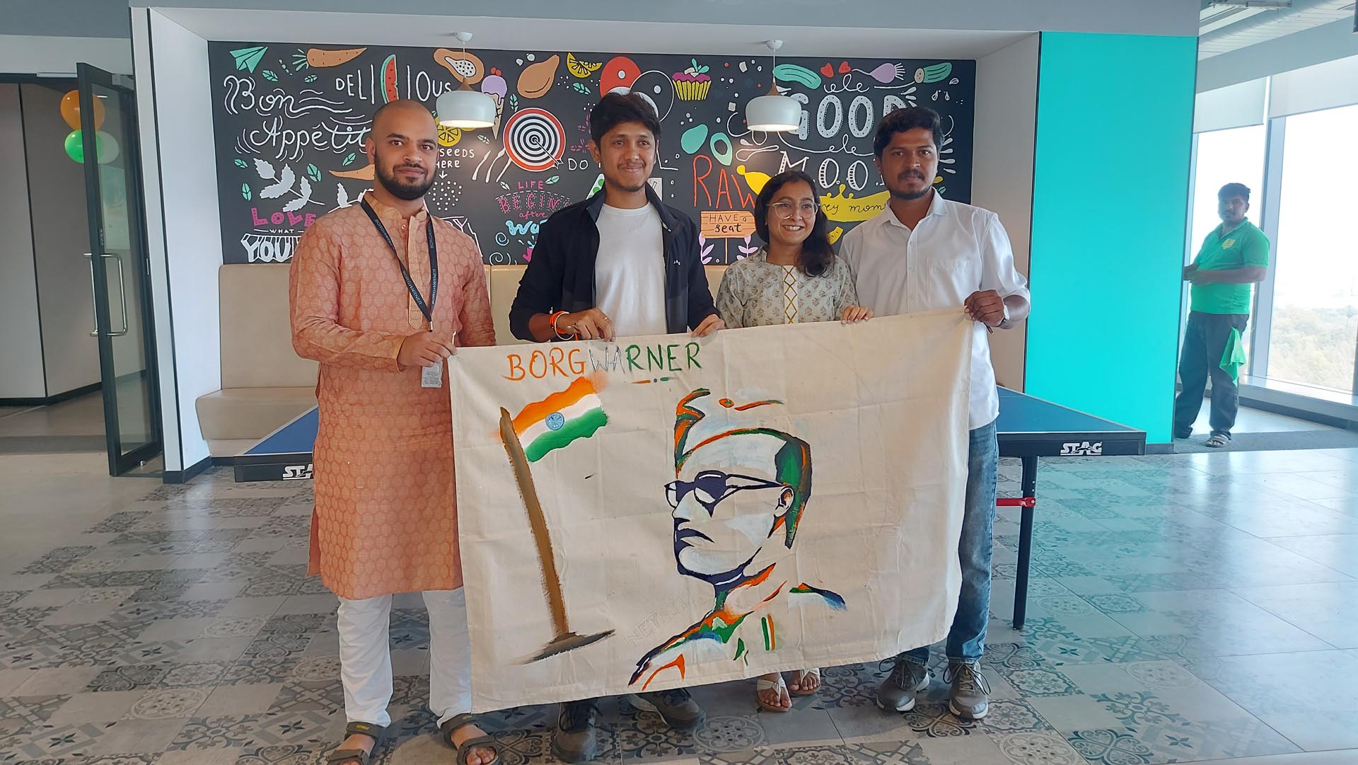 Four people proudly holding a flag