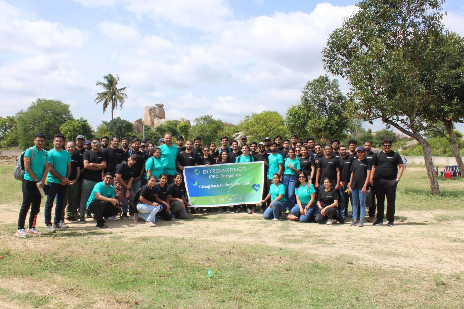 a group of people posing for a photo with a banner
