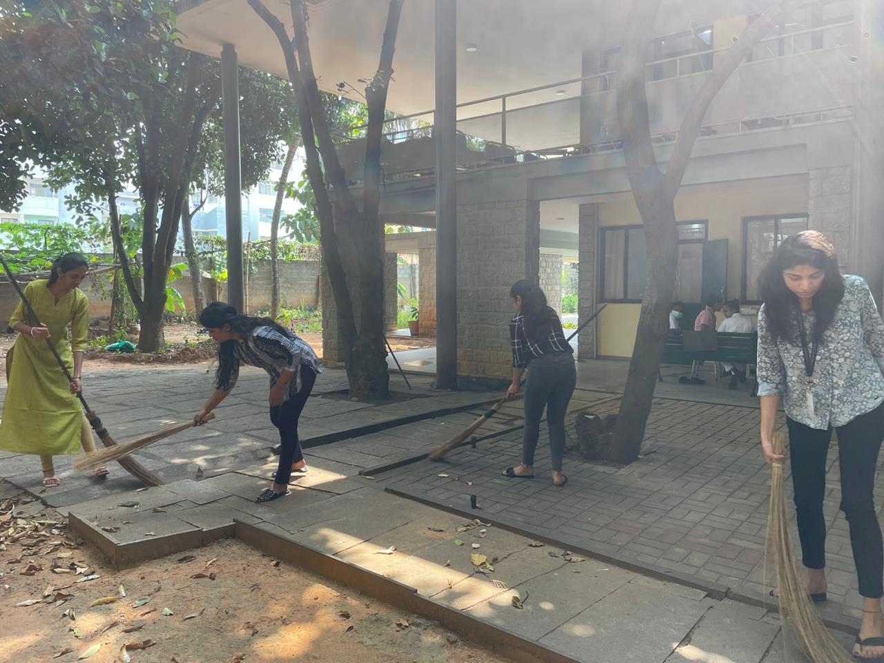 People sweeping outdoors