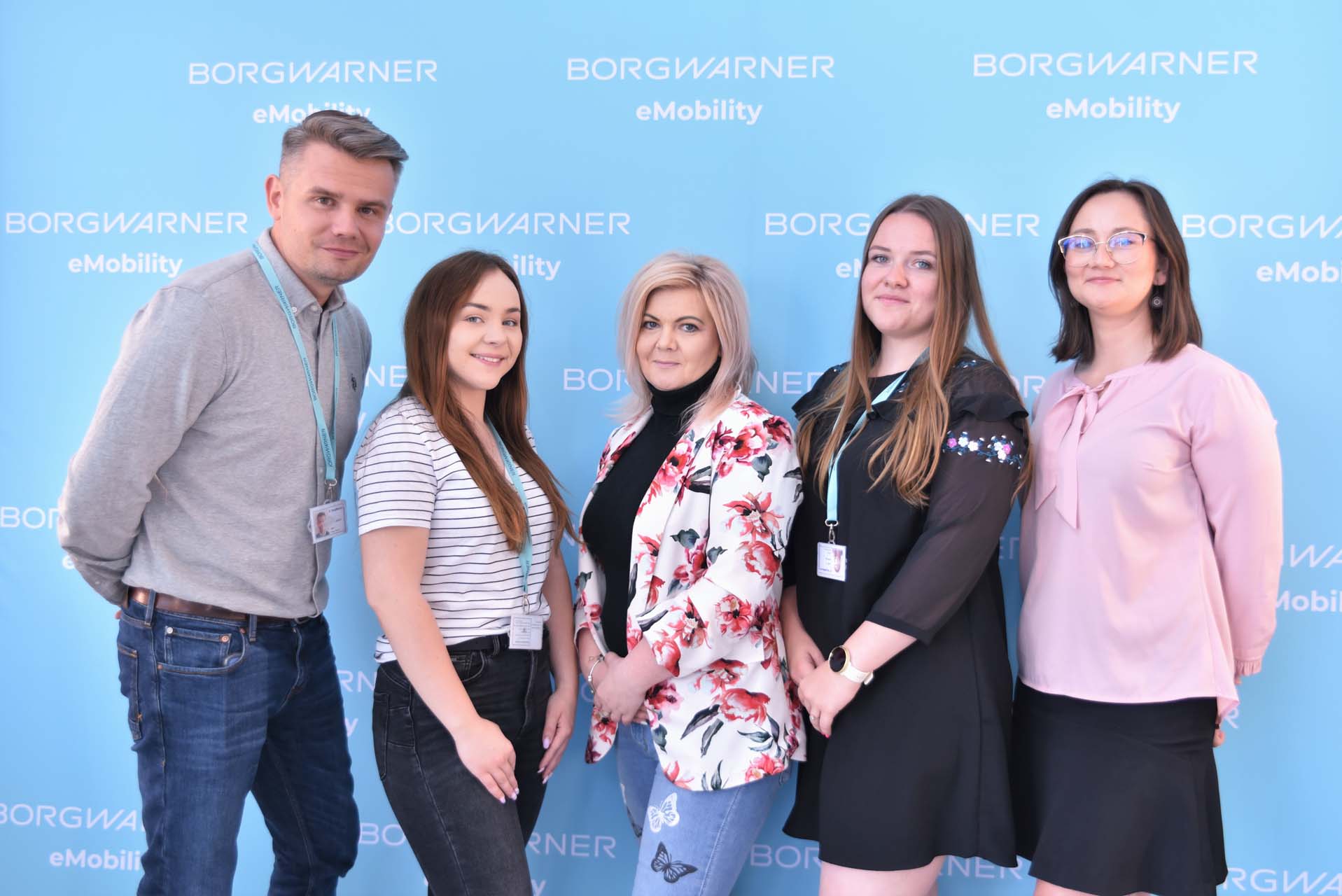 5 people in front of BorgWarner wall