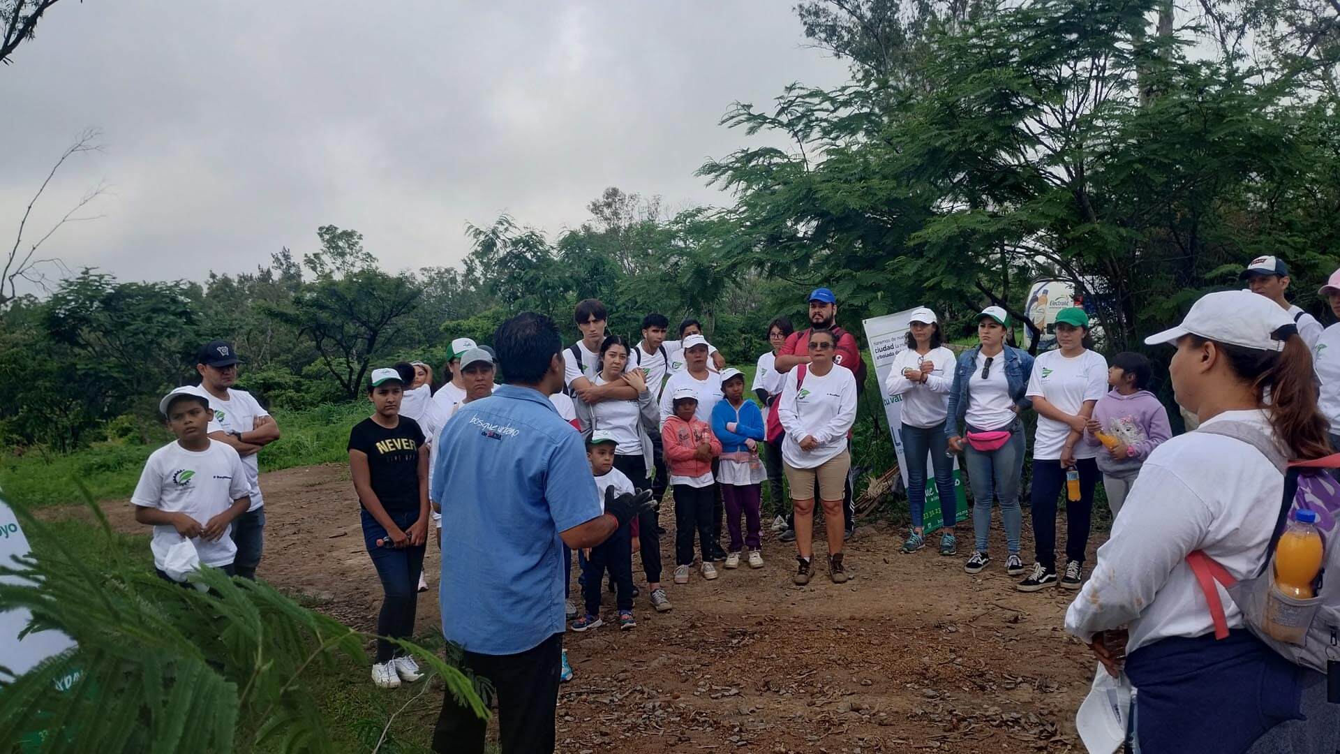 Large crowd listening to an expert standing in the woods