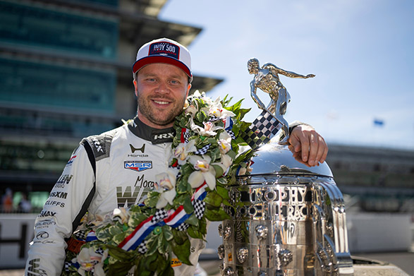 Racecar driver with tropy and wreath