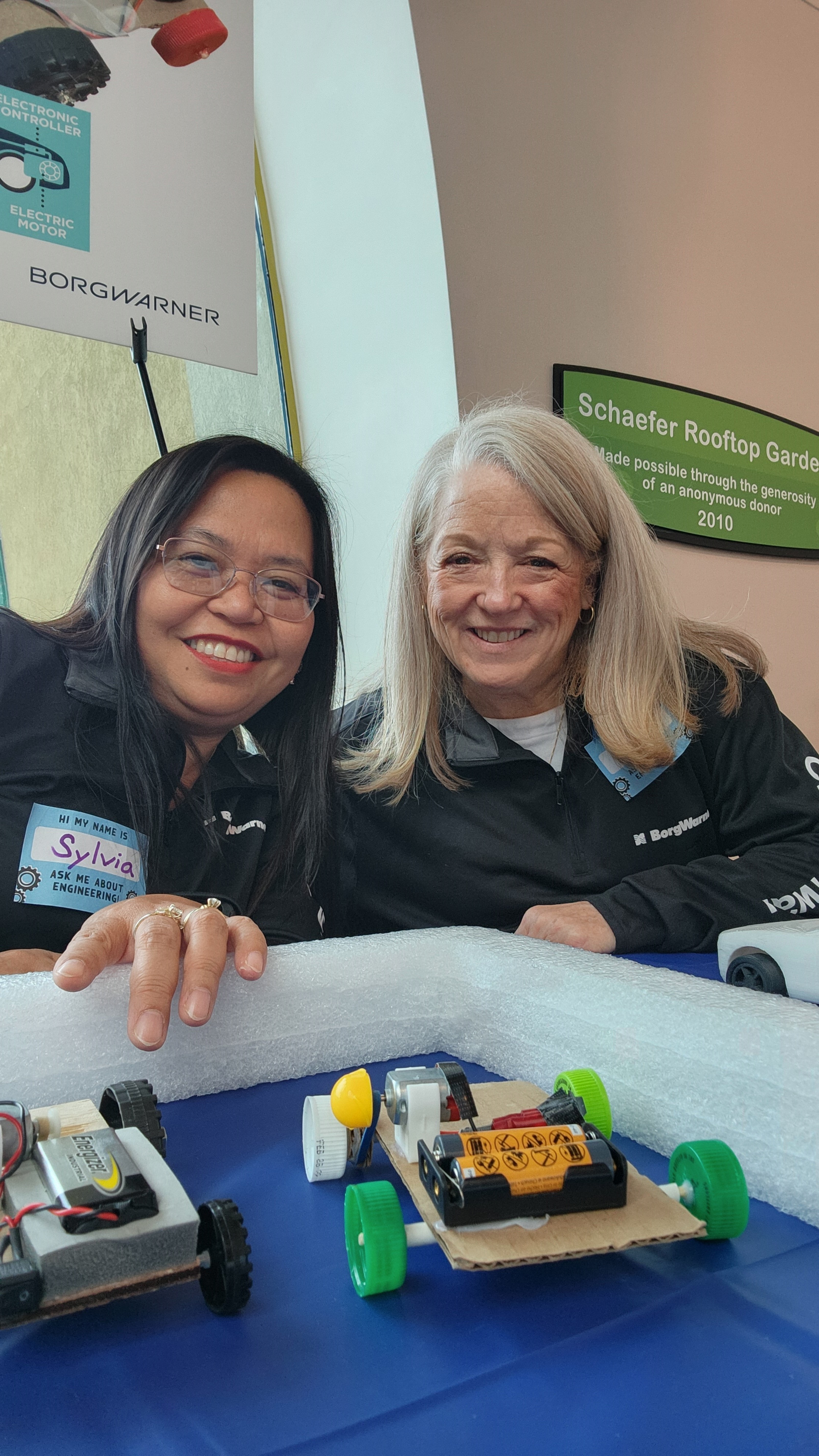 Women smiling with miniature cars