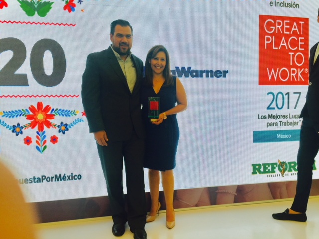 a male and a female posing for a photo at an award ceremony