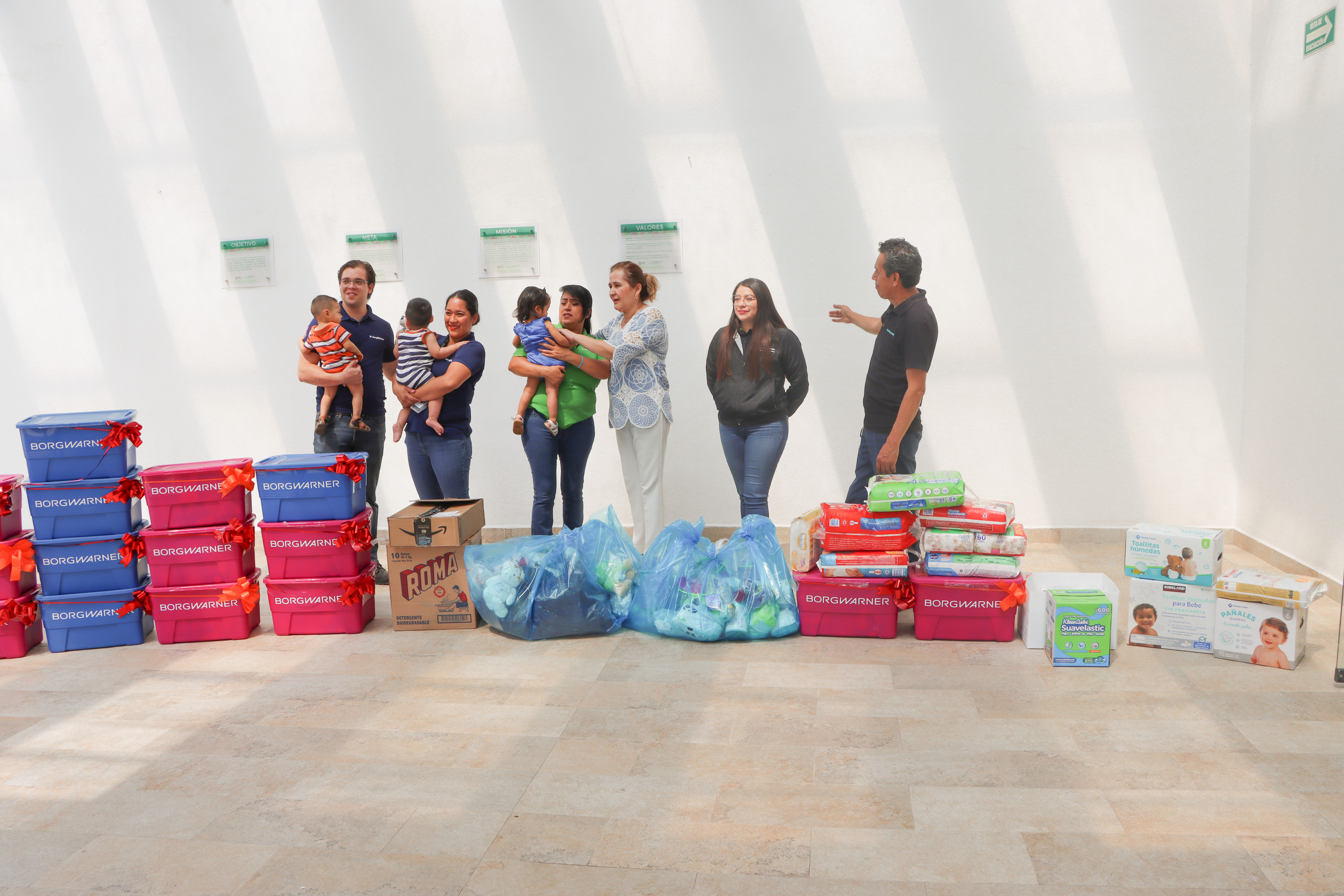 People holding babies standing near bins