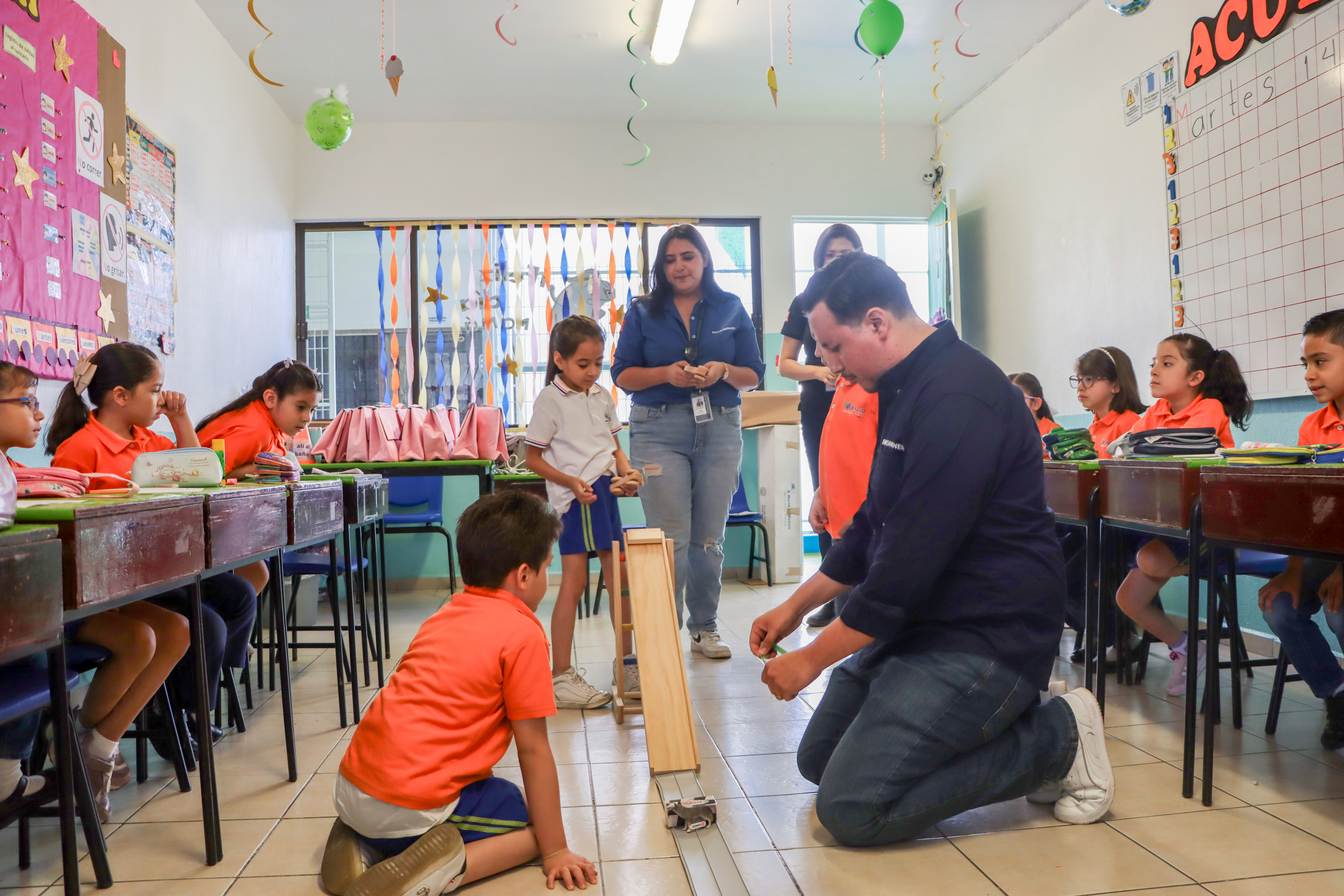 Adults helping children with minitaure car ramp