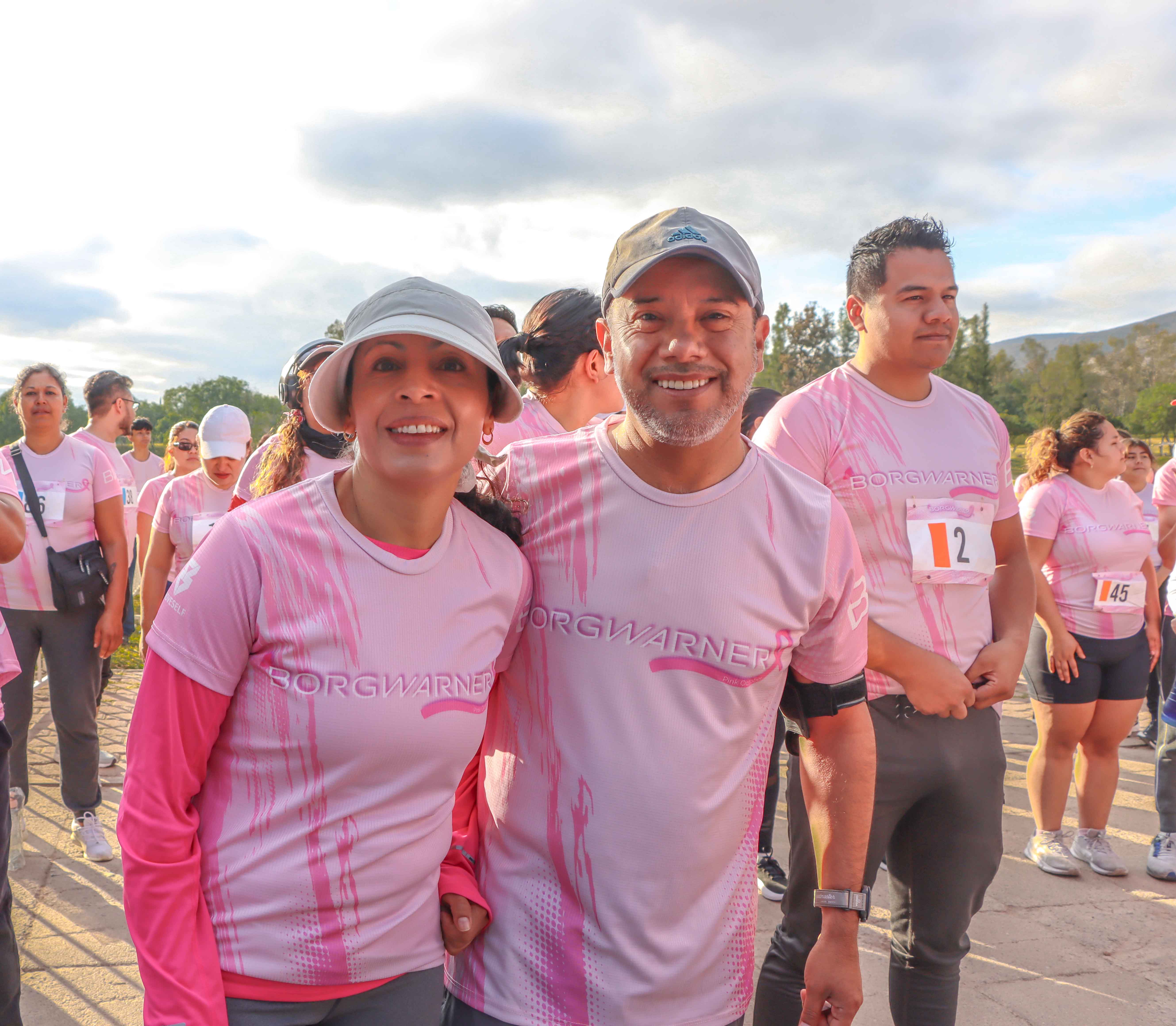 Two smiling people in pink shirts