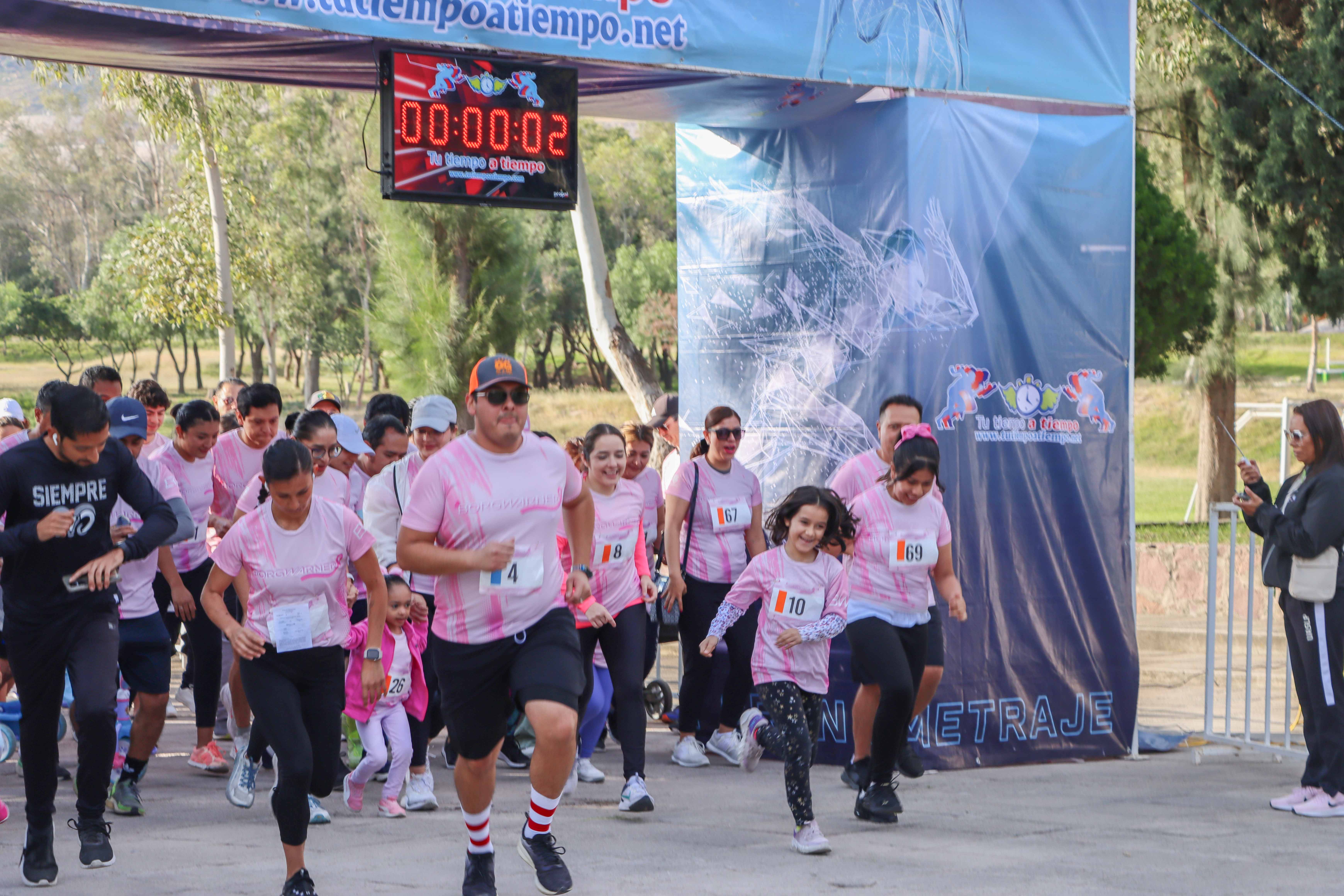 People running a race and wearing pink shirts
