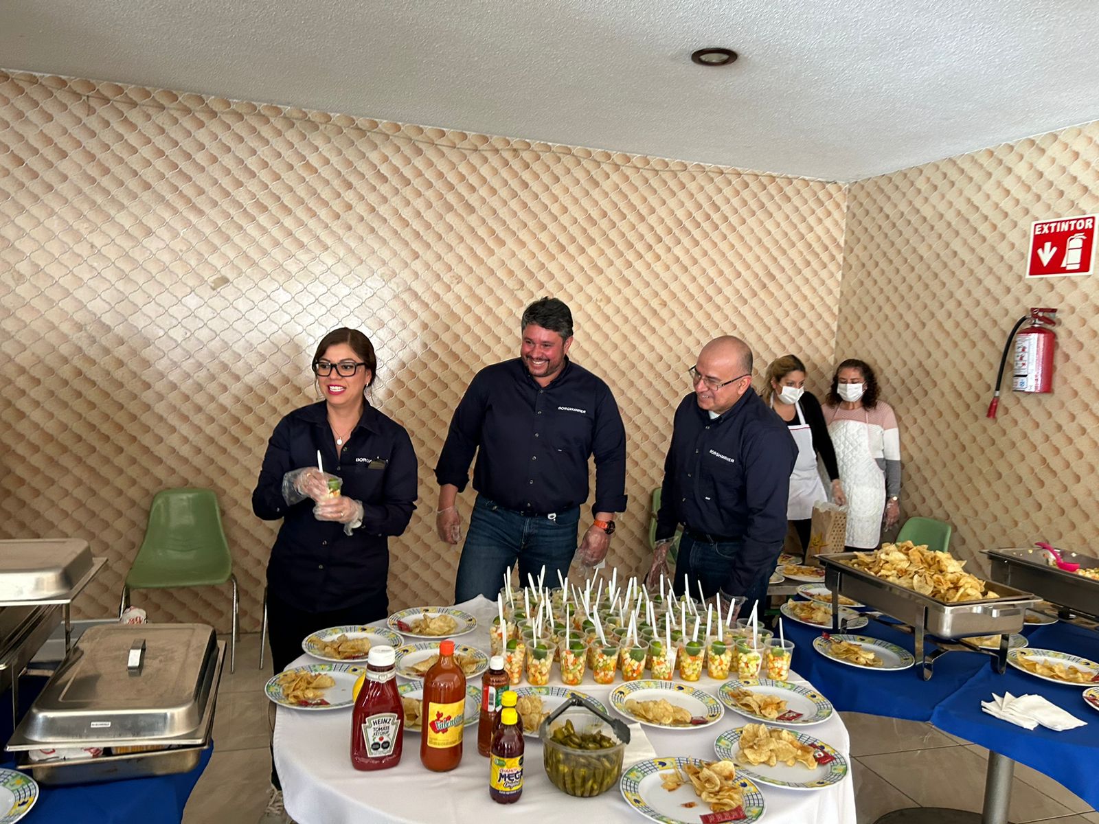 People standing behind table of food