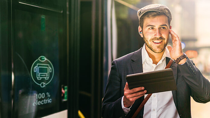 Man exiting electrified bus in a city setting